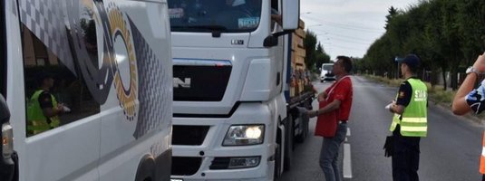 Przedstawiciel kampanii wręcza kierowcy materiały informacyjne kampanii