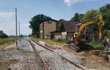 Bielany Wrocławskie - na zdjęciu koparka, odcinek nowego toru, z lewej str.toru nowe słupu oświetlenia; w tle budynek dawnej stacji; fot. Bohdan Ząbek