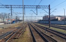 Stacja Racibórz, tory, sieć trakcyjna i pociąg przy peronie w tle, fot. Marek Firla