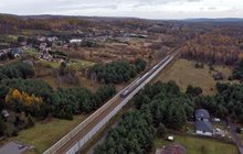 Pociąg przejeżdża przez Młoszową na wysokości planowanego wiaduktu, widok z lotu ptaka, fot. Piotr Hamarnik