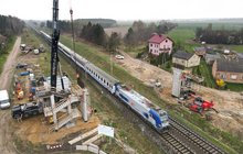 Wykonawcy na budowie wiaduktu nad torami w Ciechanowie. Widać przejeżdżający pociąg i dźwig montujący konstrukcję obiektu, fot. Grzegorz Biega (1)