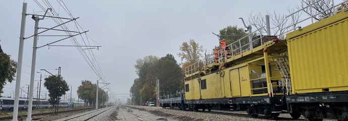 Wykonawcy wieszają nową sieć trakcyjną na przystanku Warszawa Grochów, widać pociąg trakcyjny, fot. Anna Znajewska-Pawluk