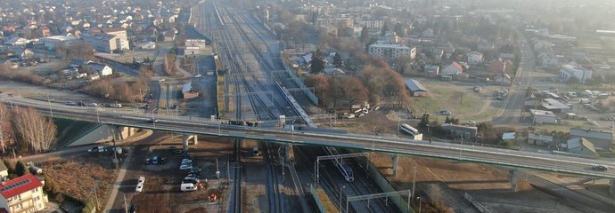 Wiadukt nad torami w Tłuszczu, dołem jedzie pociąg, fot. Artur Lewandowski PKP Polskie Linie Kolejowe SA (1)