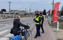 Funkcjonariusze Straży Ochrony Kolei wręczają ulotki rowerzystce przed przejazdem kolejowo-drogowym w Siedlcach; fot. Anna Znajewska-Pawluk