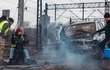 Ekipa filmowa koło dymiącego wraku samochodu na torach.