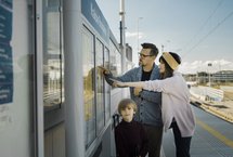 Pasażerowie przy gablocie z rozkładem jazdy. Źródło PKP Polskie Linie Kolejowe S.A.