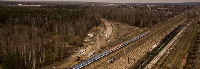 Widok z góry na prace na łącznicy w Zawierciu, po torach jedzie pociąg PKP Intercity, są też pociągi towarowe, fot. Szymon Grochowski