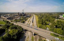 Pociąg towarowy jedzie po nowym torze w okolicach stacji Bytom Bobrek, widać wiadukt drogowy i tereny przemysłowe, fot. Szymon Grochowski