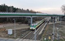 Mokra Wieś - wiadukt nad torami dołem jedzie pociąg, fot. Artur Lewandowski PKP Polskie Linie Kolejowe SA