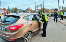Samochód przed przejazdem kolejowo-drogowym, funkcjonariusz SOK wręcza ulotkę kierowcy fot. Przemysław Zieliński PKP PLK