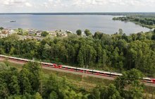 Pociąg jedzie między Wieliszewem a Zegrzem, w tle widać jezioro i las - fot. A.Lewandowski, P.Mieszkowski