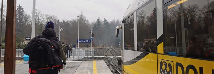 Przystanek Jedlina-Zdrój. Widać pociąg na stacji, turystów na peronie oraz drogowskaz dla osób z ograniczoną możliwością poruszania się. Fot. M. Pabiańska
