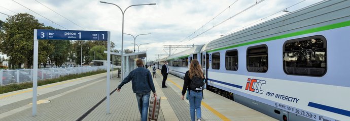 Podróżni oraz pociąg na stacji w Małkini.