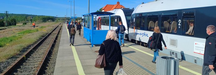 Pociąg przy peronie i podróżni na stacji Somonino. fot. Przemysław Zieliński PLK