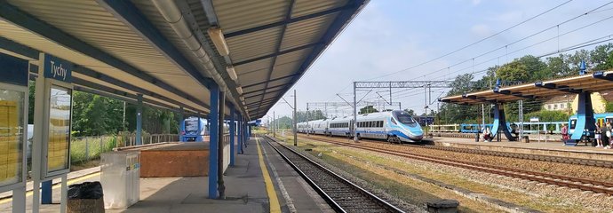 Stacja Tychy, pociąg wjeżdża na peron, pod wiatą tablica informacyjna, fot. Katarzyna Głowacka