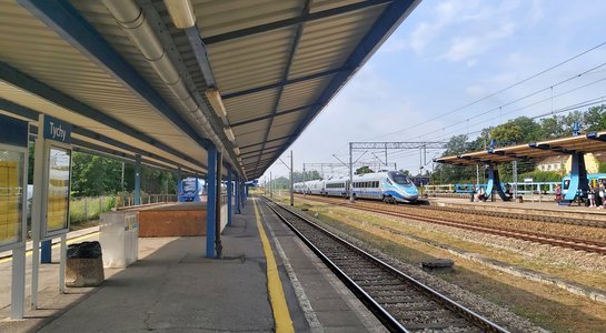 Stacja Tychy, pociąg wjeżdża na peron, pod wiatą tablica informacyjna, fot. Katarzyna Głowacka