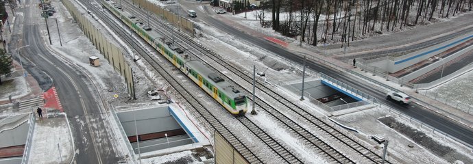 Skrzyżowanie bezkolizyjne w Kobyłce, widać pociąg, jezdnię i ścieżkę rowerową w tunelu pod torami, fot. A.Lewandowski, P.Mieszkowski