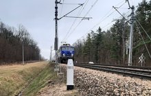 Urządzenie UOZ przy torach, widać nadjeżdżający pociąg, fot. Grzegorz Łubik