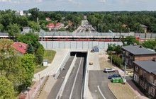Widok z góry na nowy tunel pod torami w Legionowie, widać tory, przejeżdzający pociąg i nowe drogi dojazdu do tunelu, fot. P. Mieszkowski