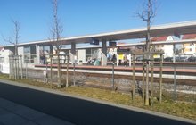 Otoczenie stacji Wągrowiec, w tle podróżni stojący na zadaszonym peronie_fot.Radek Śledziński