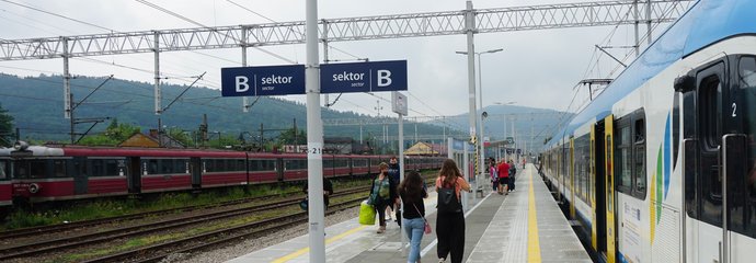 Sucha Beskidzka - pasażerowie są na peronie , obok stoi pociąg, fot. Błażej Mstowski