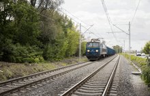 Pociąg towarowy jedzie po nowych torach na odcinku Zabrze Biskupice – Maciejów Północny, widać też drogę i samochody, fot. Łukasz Hachuła