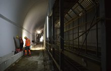 Wnętrze tunelu. Widoczna nowa, wykończona obudowa obiektu oraz konstrukcja tunelu w tunelu pozwalająca na przejazd pociągów podczas prac. Fot. M. Pabiańska
