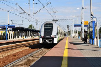 Pociąg przy peronie na stacji Legionowo, pasażerka z rowerem, fot. Martyn Janduła
