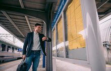 Pasażer przy gablocie z rozkładem jazdy. Autor PKP Polskie Linie Kolejowe SA