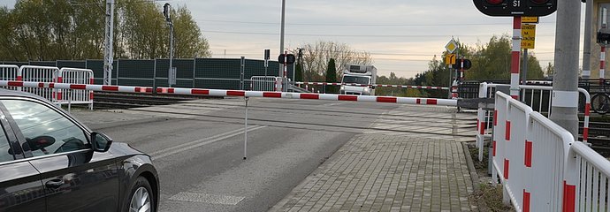 Samochód stojący przd zamkniętym szlabanem na przejeździe kolejowo-drogowym Łowicz - Myślaków