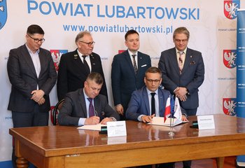Przedstawiciele PLK SA i wykonawcy podpisują umowę na wykonanie kładki nad torami w Lubartowie, w tle przedstawiciele rządu i samorządu, fot. Krzysztof Dudziński