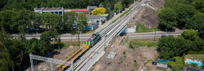 Pociąg towarowy przejeżdża nowym torem na odcinku Zabrze Biskupice – Maciejów Płn, obok układany tor, widok z góry, fot. Szymon Grochowski