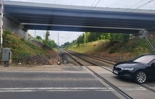 Przejazd kolejowy na ul. Lutyckiej w Poznaniu, z przodu auto, w tle nowy wiadukt_fot.Radek Śledziński