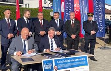 Przedstawiciele PLK i samorządu podpisują umowę na realizację projektów Kolej Plus, za siedzącą dwójką mężczyzn stoji grupa pozostałych działaczy, fot. Anna Znajewska-Pawluk