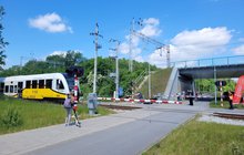 Skrzyżowanie kolejowo-drogowe we Wrocławiu, widać przechodniów i przejeżdżający pociąg, fot. Mirosław Siemieniec