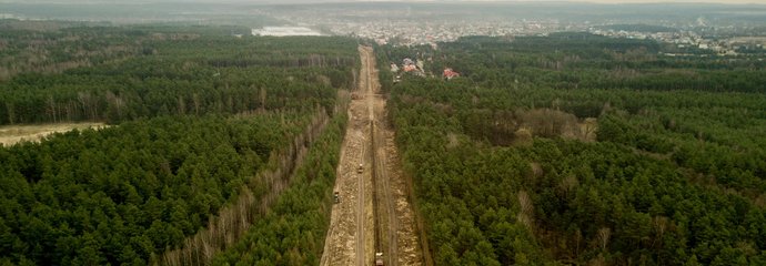Budowa linii kolejowej w Siewierzu, widok z lotu ptaka na budowaną linię, widać maszyny, dookoła lasy, fot. Szymon Grochowski
