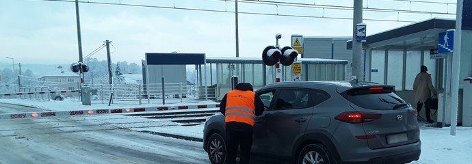 Przedstawiciele PLK i SOK wręczają ulotki kierowcom przed przejazdem kolejowo-drogowym. fot. PLK SA