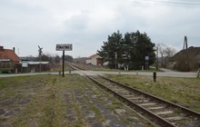 Przystanek Poniatowice. Widok ze starego peronu na przystanek, tablice z nazwą miejscowości, przejazd kolejowoy z krzyżem św. Andrzeja i znakiem STOP. Fot. M.Pabiańska