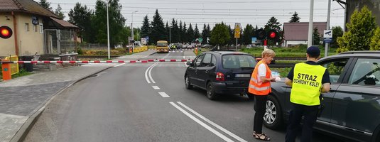 Samochody przed zamkniętym przejazdem. Kierowcy otrzymują materiały od sokisty i koordynatorki kampanii.