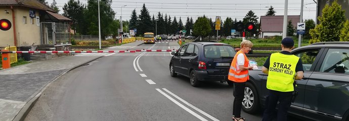Samochody przed zamkniętym przejazdem. Kierowcy otrzymują materiały od sokisty i koordynatorki kampanii.