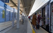 Podróżni wsiadający do pociągu na stacji Rzeszów Główny, po lewej gablota informacyjna. fot. Szymon Grochowski
