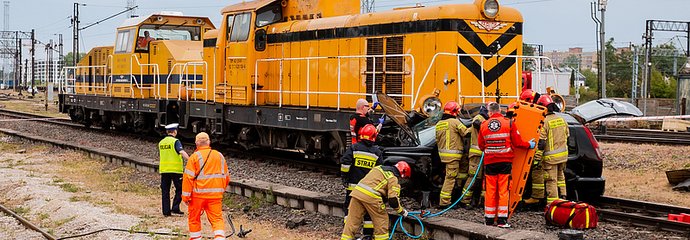 Akcja ratunkowa służb przy wraku samochodu po zderzeniu z lokomotywą.