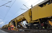 Robotnicy nadzorują pracę maszyny. Widac uniesiony tor z podkładami. Fot. M. Pabiańska 11.24r.