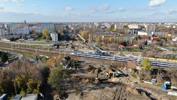 Teren przygotowany pod budowę przystanku Radom Wschodni, widać pociąg jadący po torach, wykonawców i maszyny budowlane, P. Mieszkowski, A.Lewandowski
