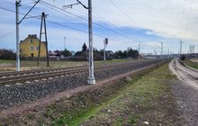 Pociąg i tory w miejscu nowego przyststanku we Wronkach, słupy sieci trakcyjnej, w tle dom_fot.Radek Śledziński