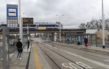 Przebudowany wiadukt kolejowy nad ul. Długą we Wrocławiu; na zdjęciu nowe konstrukcje wiaduktu; pod wiaduktem przystanek tramwajowy, na wiadukcie pociąg pasażerski 