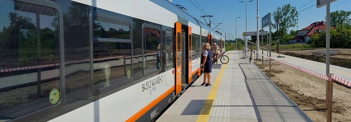 Podróżny wysiada z pociągu na peronie w Dębskiej Woli fot. Robert Hurkała PKP Polskie Linie Kolejowe S.A.