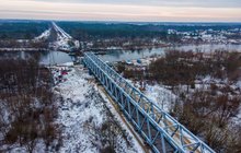 Widok z lotu ptaka na nasuwanie mostu kolejowego na rzece Narew. W oddali widać las. fot. Łukasz Bryłowski, PLK