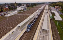 Widok z lotu ptaka na stację Małkinia Górna, dwa pociągi pasażerskie stoją na peronach stacji. Autor Szymon Grochowski