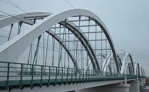 Widok na most kolejowy na Bugu. Widoczne stalowe łuki konstruktywne.